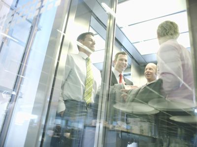 Businessmen talking in elevator