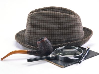 Sherlock Holmes style detective's hat, pipe, magnifying glass and pen