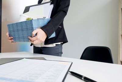 女人在办公室的桌子旁拿着盒子