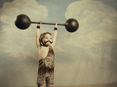 a young boy dressed as a strongman