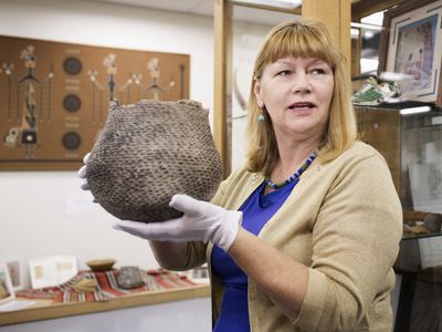 Archivist holding artifact in museum