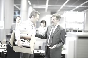 Businessman leaving office with box of personal items