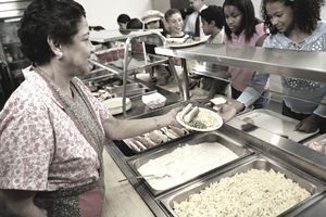 成熟的女人提供食物在食堂学生(12 - 14)