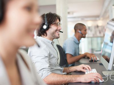 Business people with headsets working at computers in office