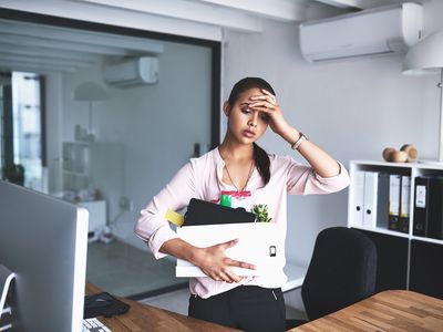 不开心的女商人在从工作中解雇后拿着她的物品盒