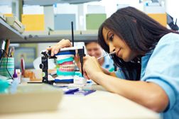 A dental technician works on dentures.