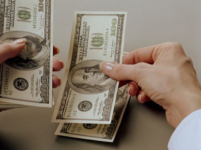 Employee counting $100 bills as their salary
