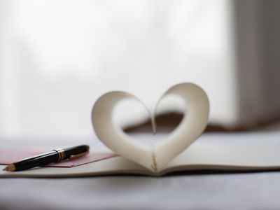 Pen and pages of notebook forming a heart-shape
