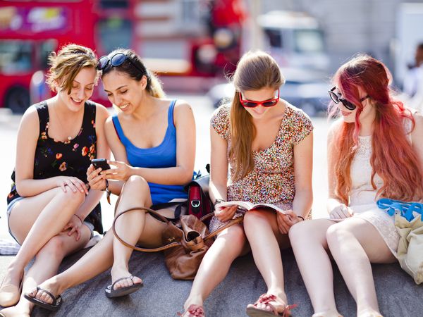 Young Adult (YA) women sitting outdoors in a city