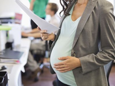 在办公室工作的怀孕女商人