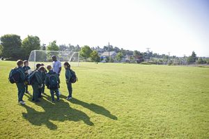 kids and coach on soccer field