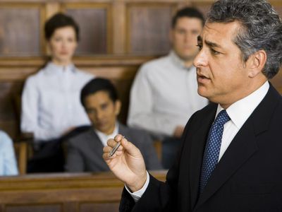 A male lawyer talking in a courtroom in front of a jury