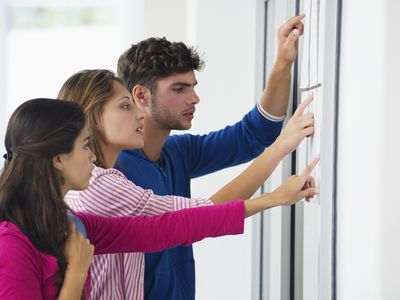 University law school students checking bulletin board for their pass/fail grades.
