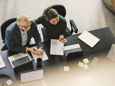 High angle view of businesswoman having discussion with colleague at table in office
