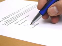 A person signing a business letter.